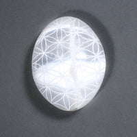 Crystal with Flower of Life pattern on a dark gray background