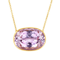 Necklace with a large lavender gemstone and gold frame on a white background