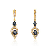 A pair of 18k gold sapphire and diamond earrings with teardrop-shaped blue sapphires at the top and round diamonds at the bottom.
