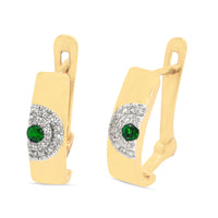A pair of 18kt gold emerald and diamond earrings with a green emerald centerpiece surrounded by smaller clear diamonds set within a gold band.