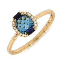 A gold ring featuring a faceted London Blue Topaz center stone, surrounded by a halo of diamonds and two Sapphire baguettes.