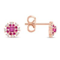 A pair of 18k gold ruby and diamond earrings with a floral design.