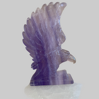 Purple crystal eagle sculpture on a white background