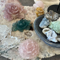 Decorative display of crystal flowers and rocks on a stone surface