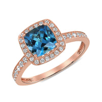 Rose Gold ring with a cushion-cut Brilliant blue Topaz gemstone, haloed in radiant diamonds with additional pavé diamonds cascading down the band