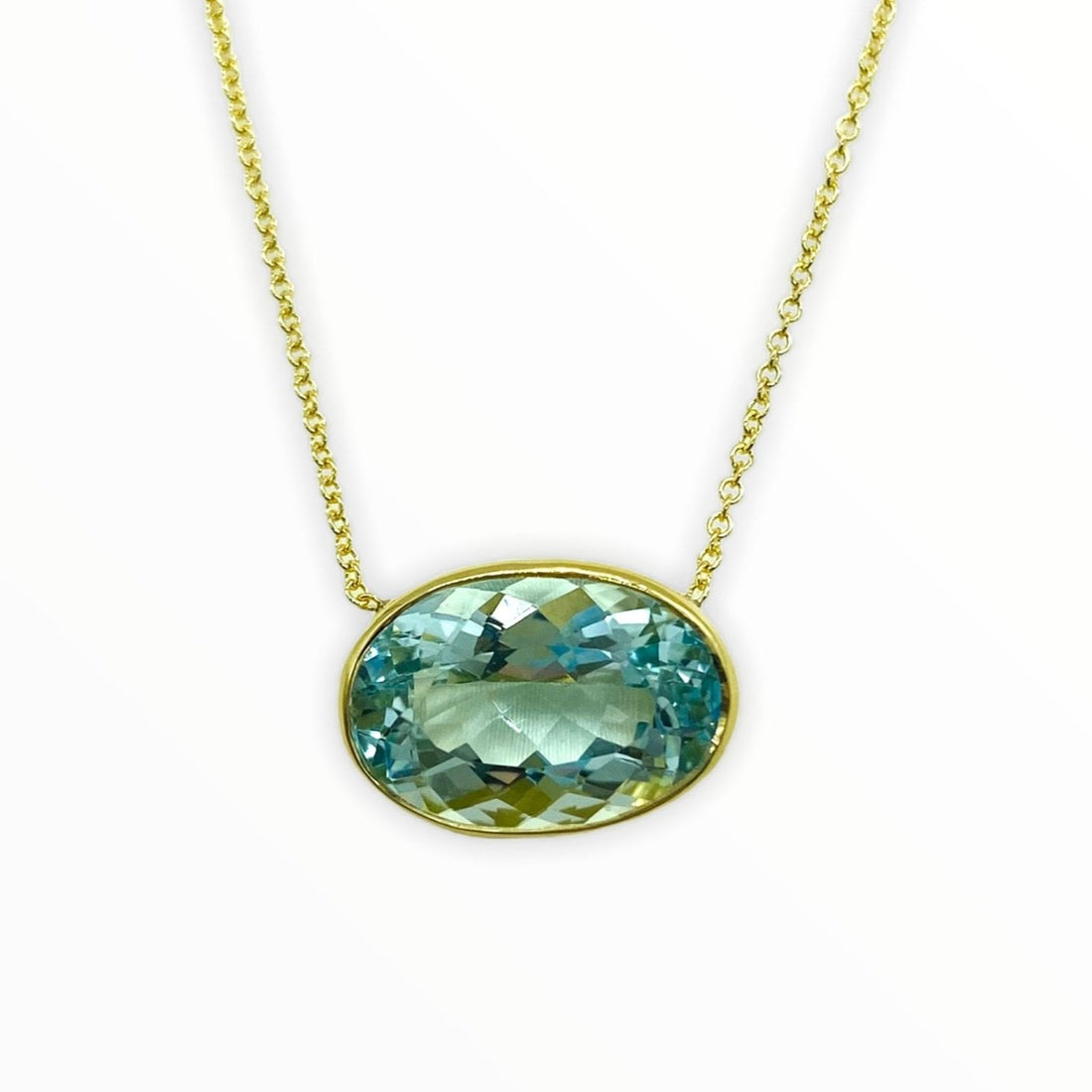 gold necklace with bright blue green oval-shaped, bezel-set aquamarine