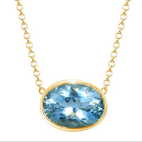 gold necklace with bright blue oval shaped bezel set aquamarine