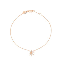 A gold bracelet featuring a central star shape with diamonds surrounded by smaller diamonds, attached to a chain.