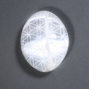Crystal with Flower of Life pattern on a dark gray background
