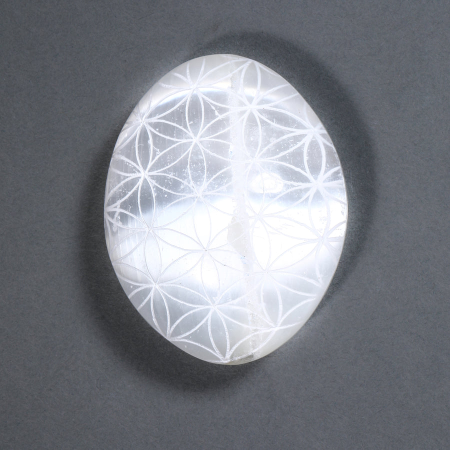 Crystal with Flower of Life pattern on a dark gray background