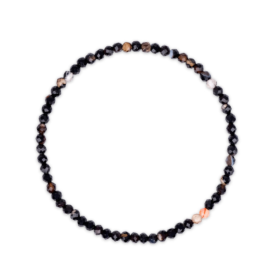 Bracelet with black, brown and clear faceted beads on a white background