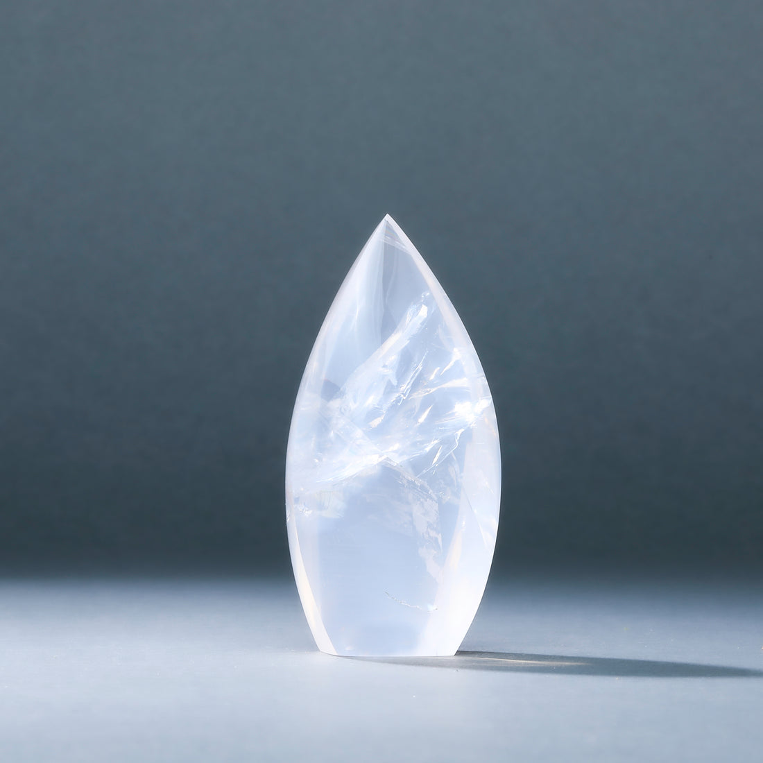 Teardrop-shaped crystal on a dark gray background