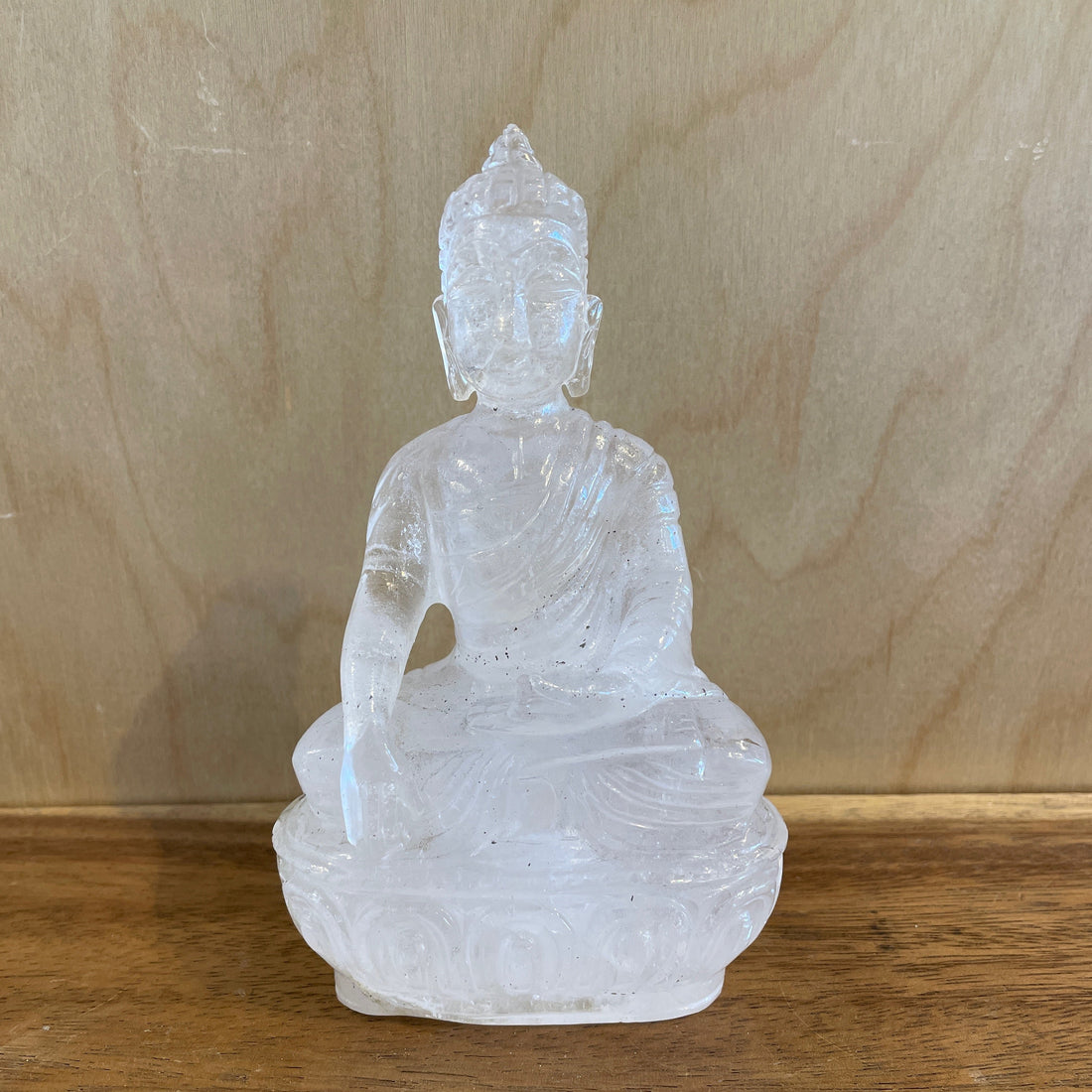 Crystal Buddha statue on a wooden surface