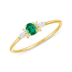 gold ring with oval emerald center gem enhanced with white sapphires set in flower pattern around it