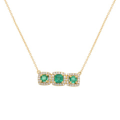 Gold necklace with three green emeralds each surrounded by diamond halo lined next to each other on a white background