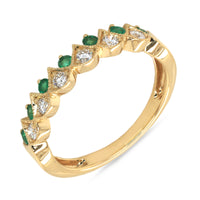 An 18k gold ring with alternating emerald and diamond stones along its band forming a crown design.