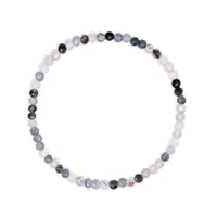 Bracelet with multicolored  white and black faceted beads with rutile inclusions visible on a white background