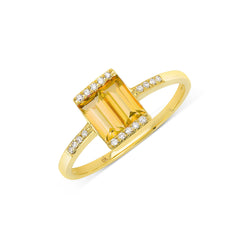 A gold ring featuring a large citrine stone centerpiece with smaller diamonds set around it.
