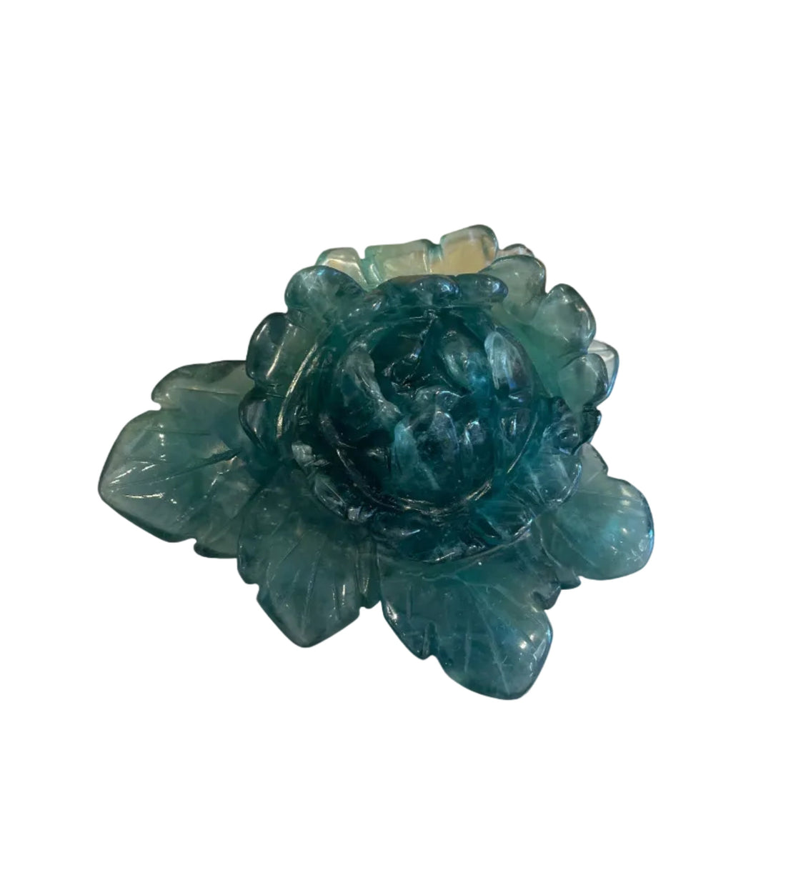 Green crystal flower on a white stone base against a wooden background