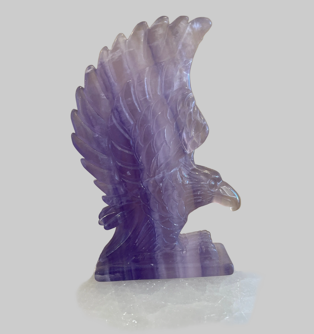 Purple crystal eagle sculpture on a white background