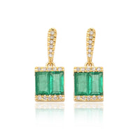 Double Emerald baguettes flanked with brilliant diamonds create an illustrious pair of 18k gold earrings
