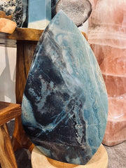 Blue and grey stone with blue and black patterns on a wooden stand.