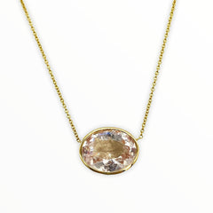gold necklace with bright irredescent oval-shaped, bezel-set faceted morganite gemstone