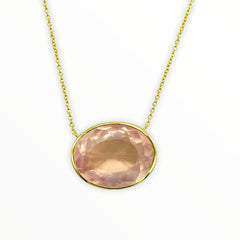 gold necklace with bright irredescent oval-shaped, bezel-set faceted rose quartz gemstone
