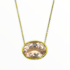 gold necklace with bright irredescent oval-shaped, bezel-set faceted rose quartz gemstone