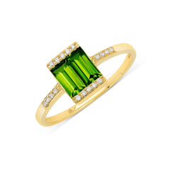 A gold ring featuring a double green tourmaline baguettes flanked by diamond bars and smaller diamonds set into the band.