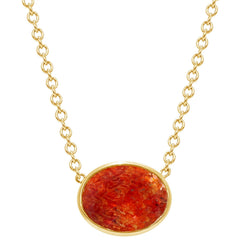 gold necklace with bright oval shaped bezel set red sunstone gem
